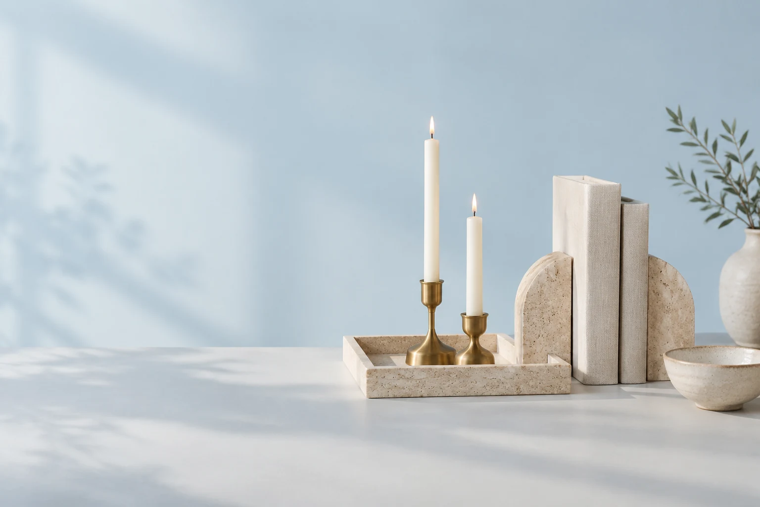 Travertine tray with brass candle holders, bookends and a ceramic bowl